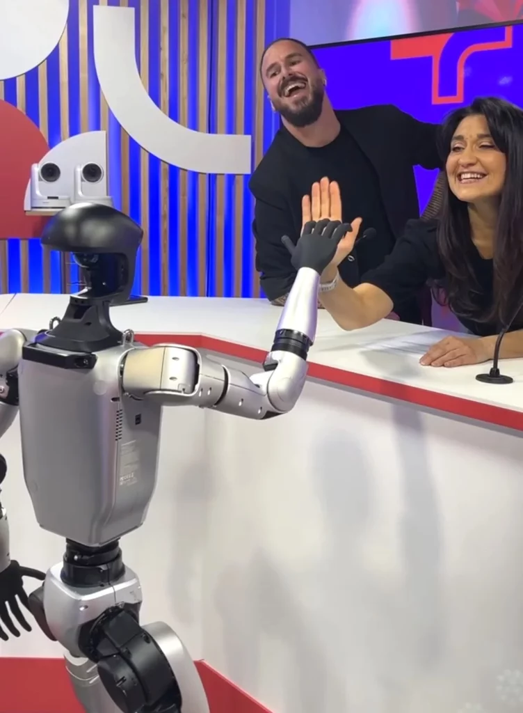 Le robot humanoïde Keyo tape dans la main de la journaliste Lucile Dailly avec le magicien mentaliste Kevin Micoud sur le plateau de l'émission Le + 