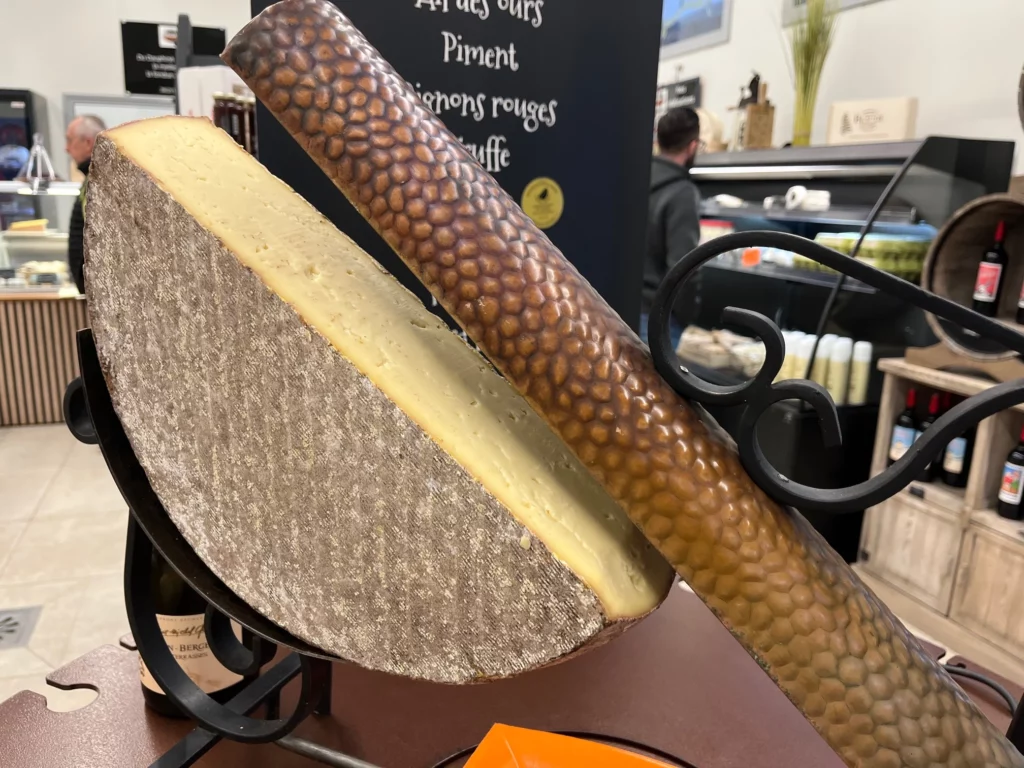 Une demi-meule de raclette sous le gril de la fromagerie Beaudé à Montferrat