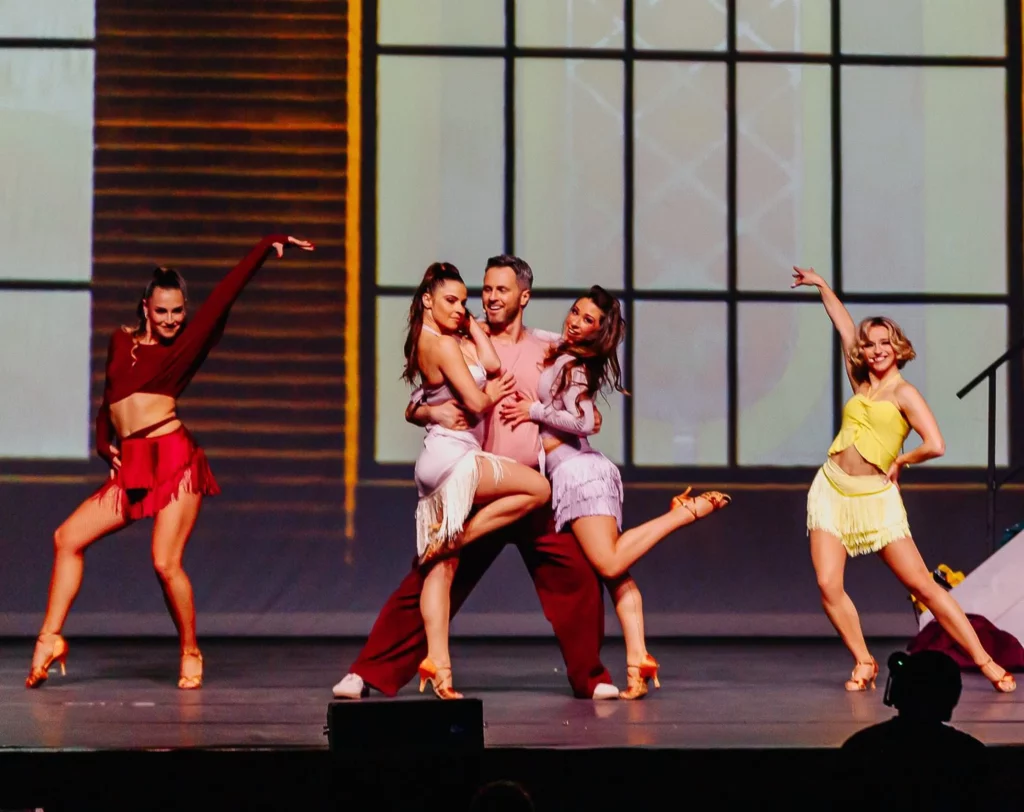 Les danseurs Chrisitan Millette et Denitsa Ikonomova sur scène avec d'autres danseuses sur scène dans la comédie musicale Bonne Nouvelle