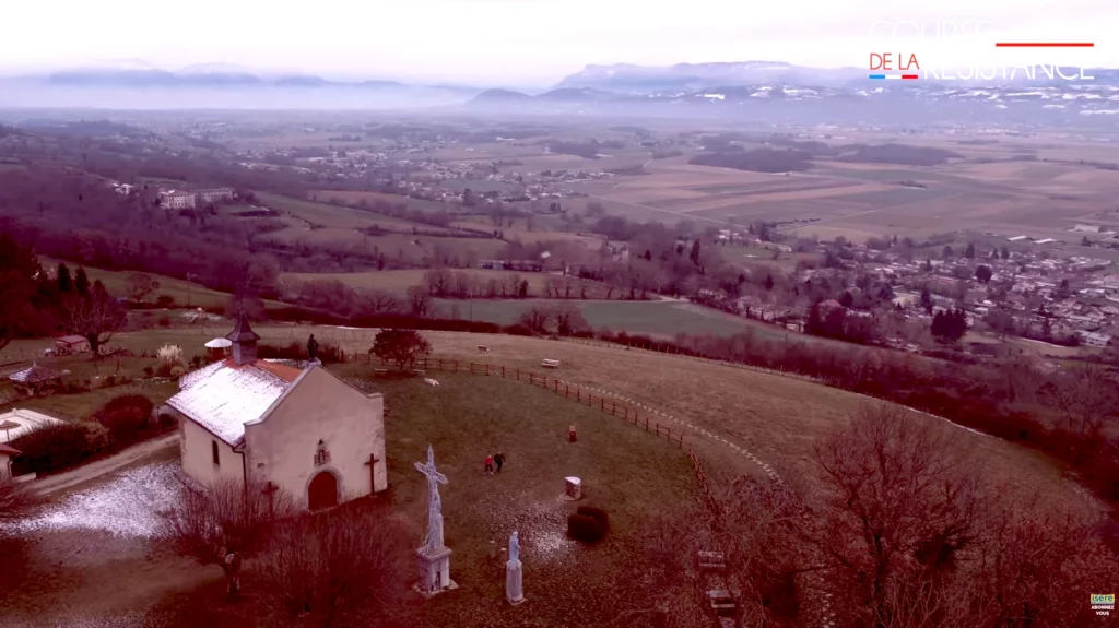 La Course de la Résistance, paysage de la Bièvre avec une église et des coureurs