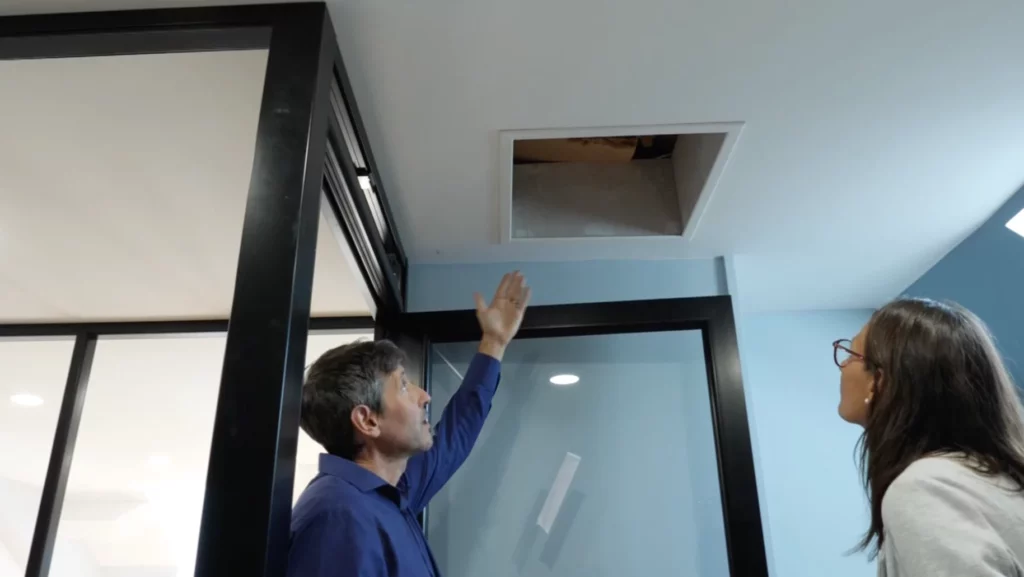 deux personnes observent les travaux sur un mur qui a fait l'objet de rénovation thermique