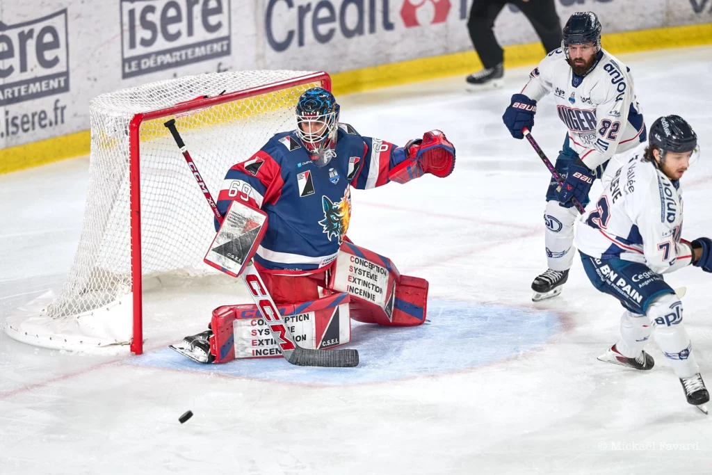 Le gardien de buts des brûleurs de Loups Matja Pintaric dans sa cage avec un palet près de lui