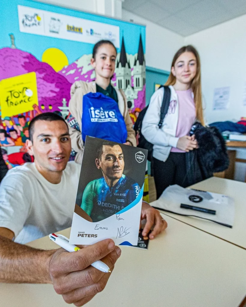 Nans Peters signe des autographes et montre une photo de lui devant des élèves