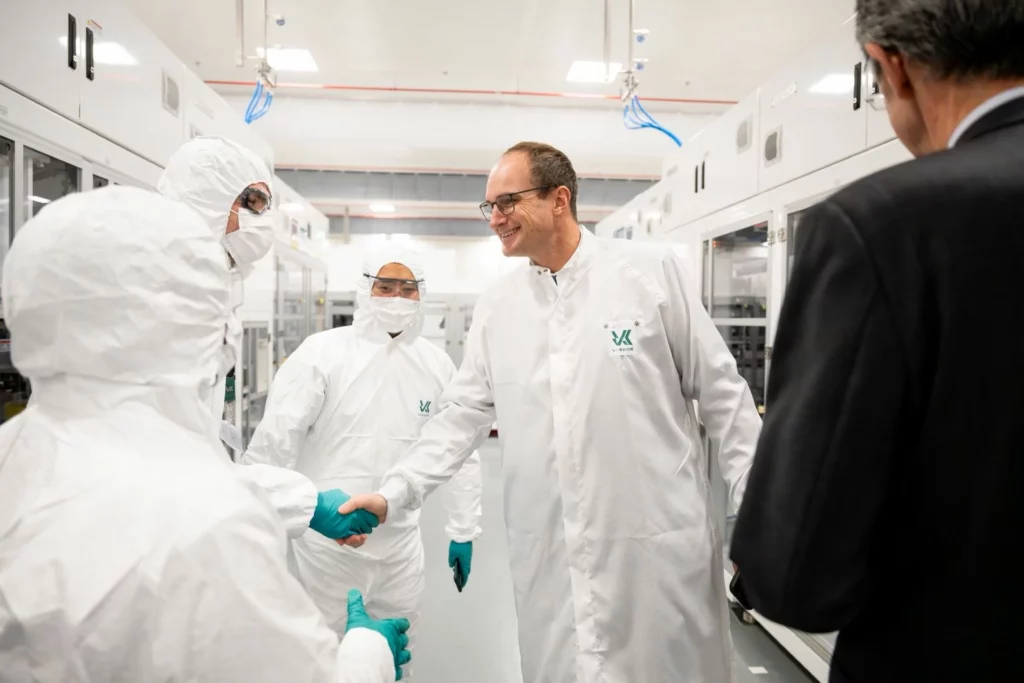 Le PDG de Verkor Benoît Lemaignan serre une main dans une salle blanche à des personnes en combinaison