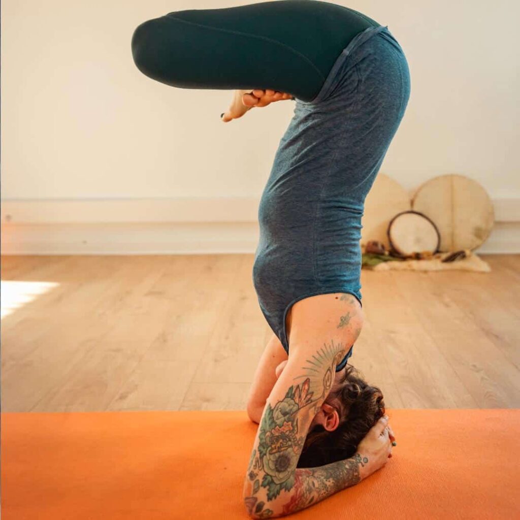 Elsa Rossetto en position de yoga, avec ses tatouages apparents sur le bras