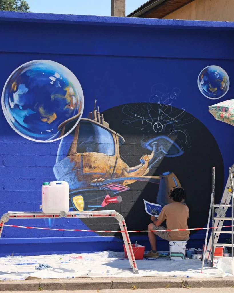 un street artiste peint sur un mur