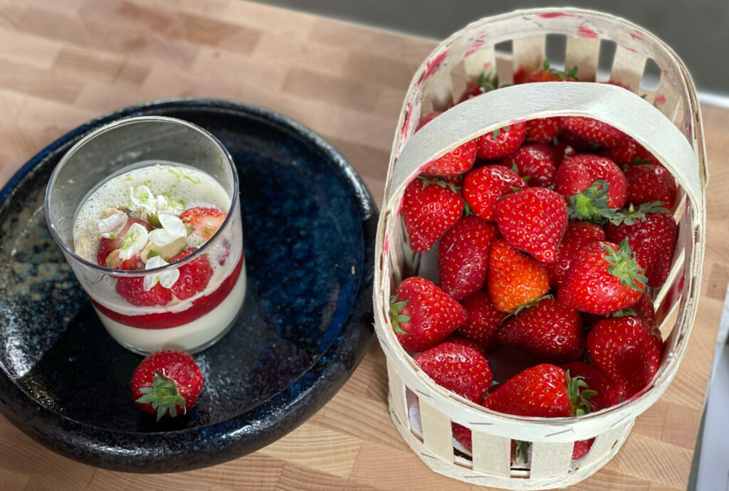 Une panna cotta aux fraises avec un panier de fraises