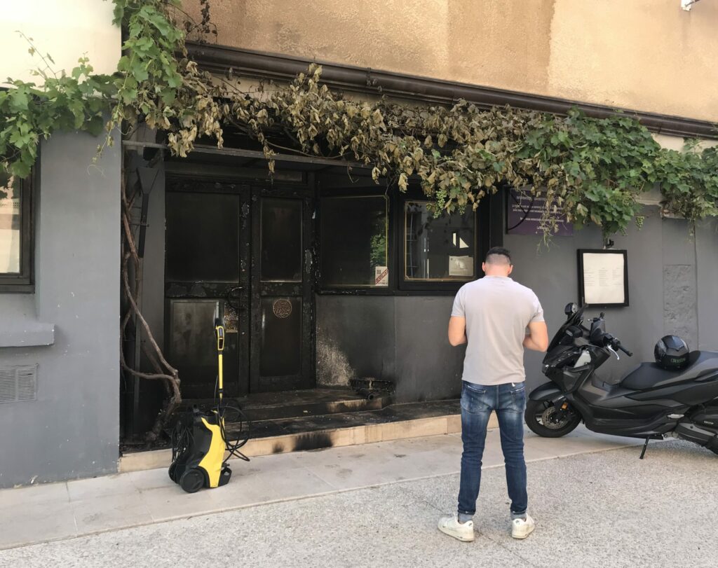la façade d'un restaurant incendié à grenoble, le propriétaire de dos